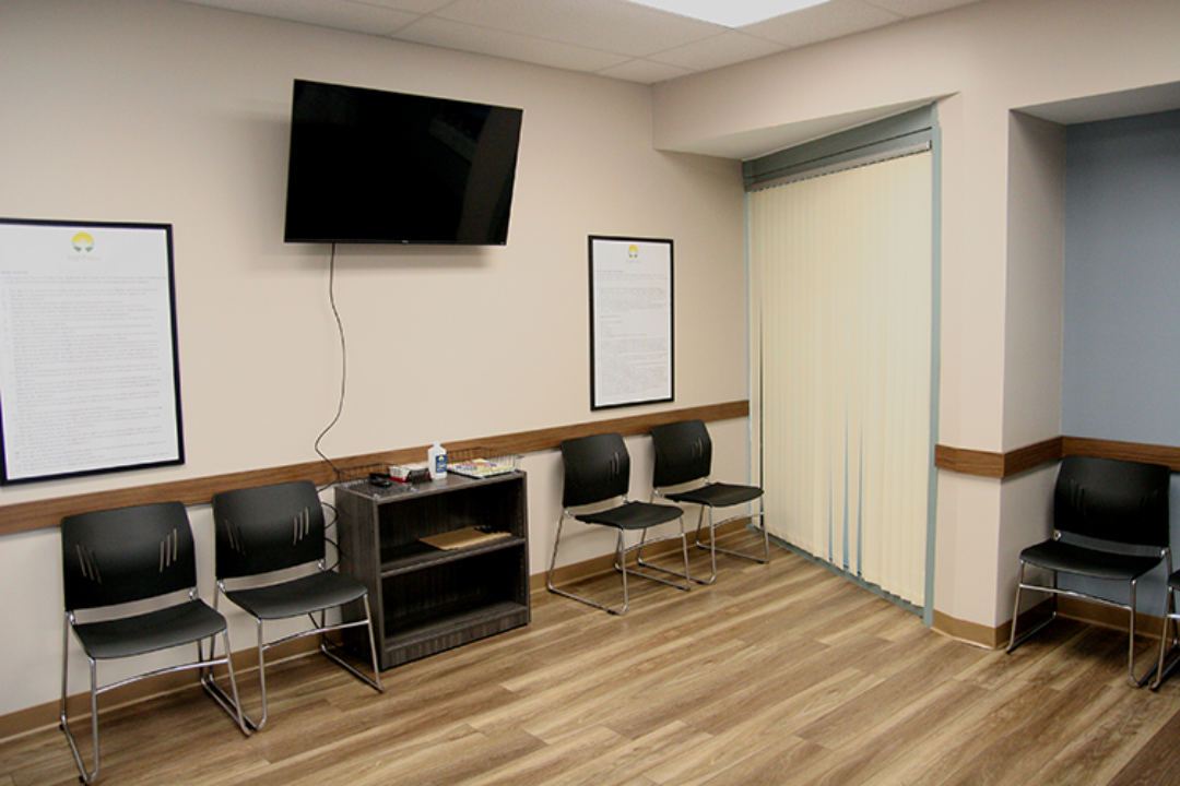 Waiting area with chairs, television, and wood flooring