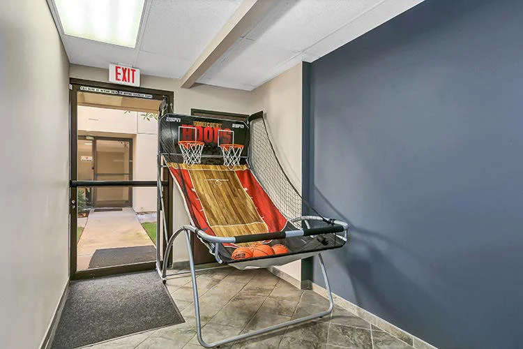 Arcade-style basketball hoop setup near facility entrance