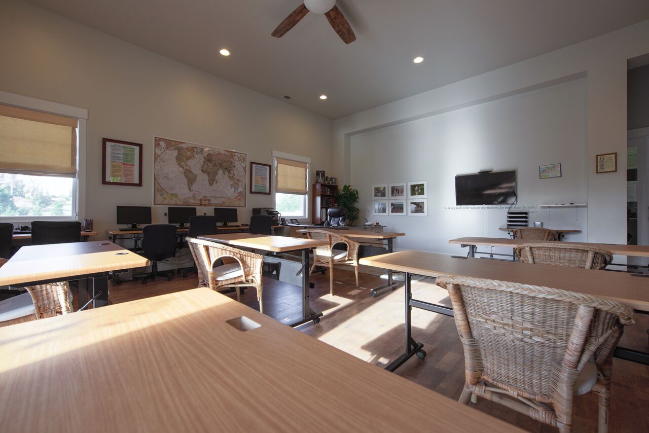 Classroom with a TV, desks and chairs.