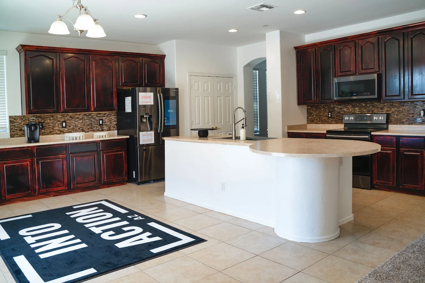 Spacious kitchen with island, dark cabinets, and appliances