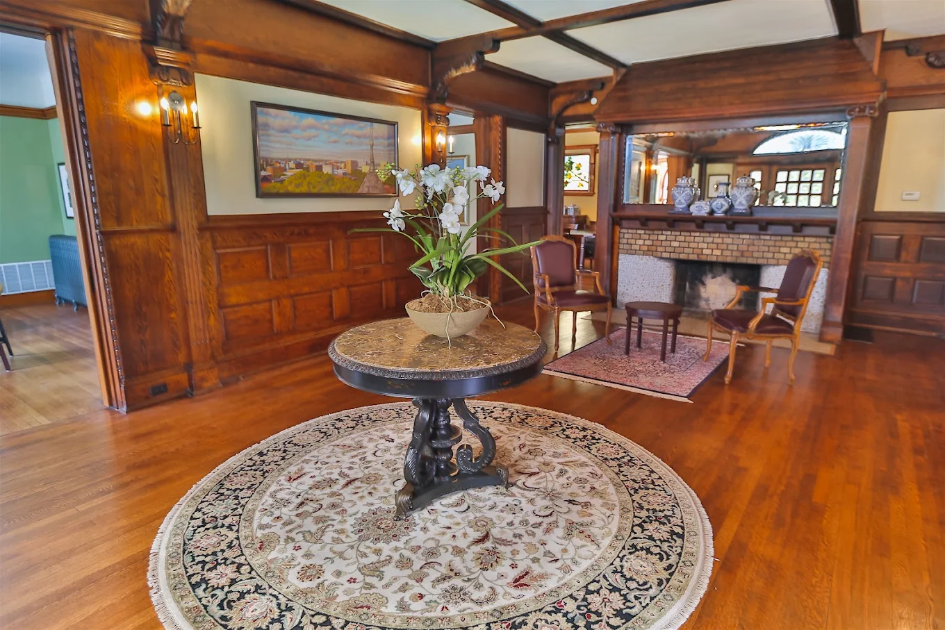 Historic lobby with wood paneling, fireplace, and floral centerpiece