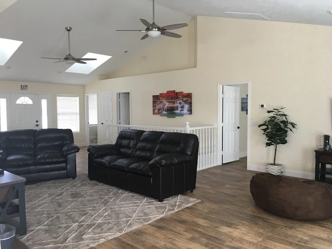 Spacious living room with black leather couches