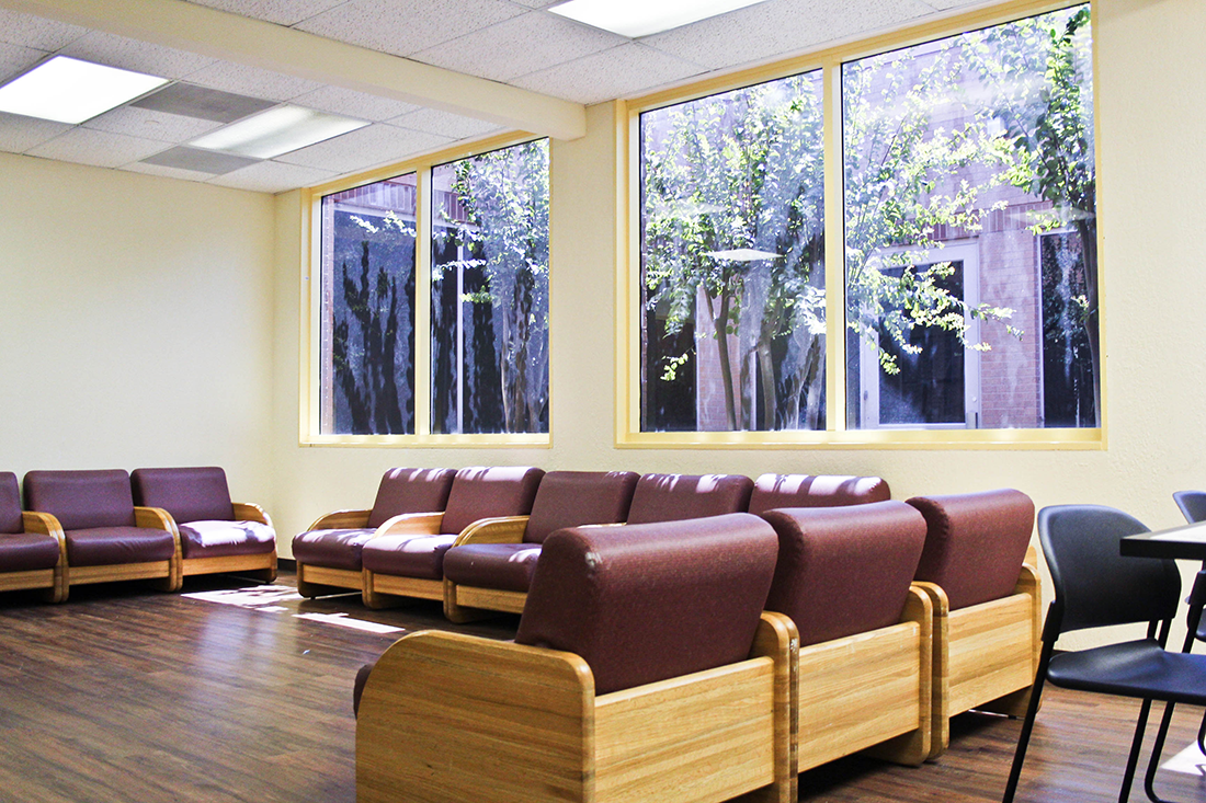 Waiting area with cushioned chairs and large windows