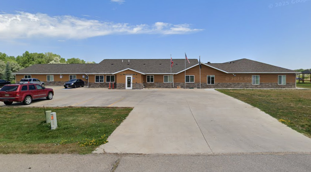 Single-story facility with parking lot and flags by entrance