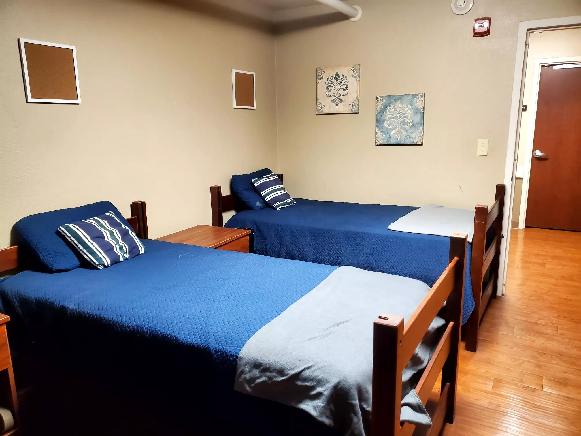 Shared room with two beds, nightstand, and wall décor