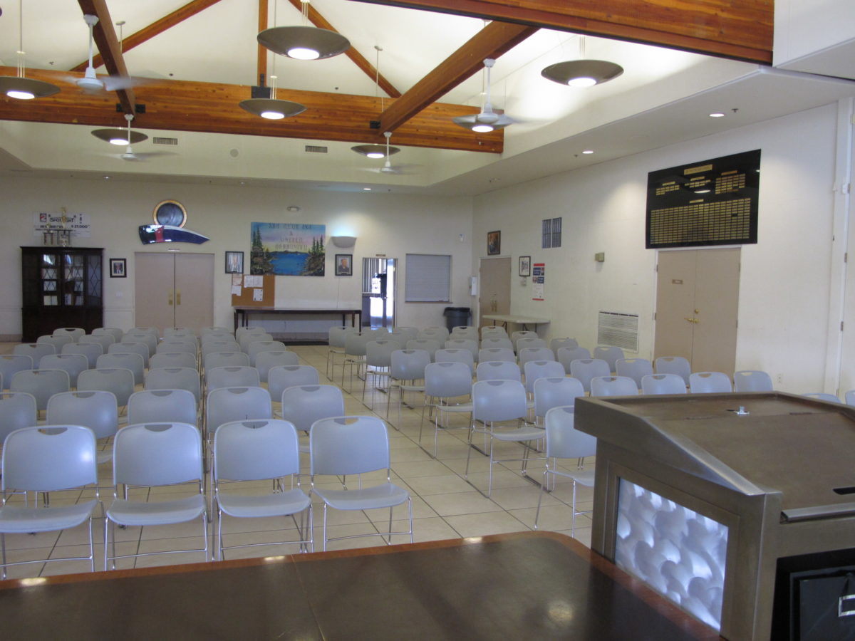 Rehab meeting room with rows of chairs and wood beams.