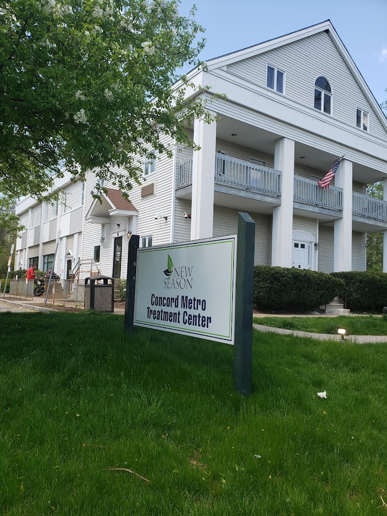 A sign for Concord Metro Treatment Center in front of a white building.