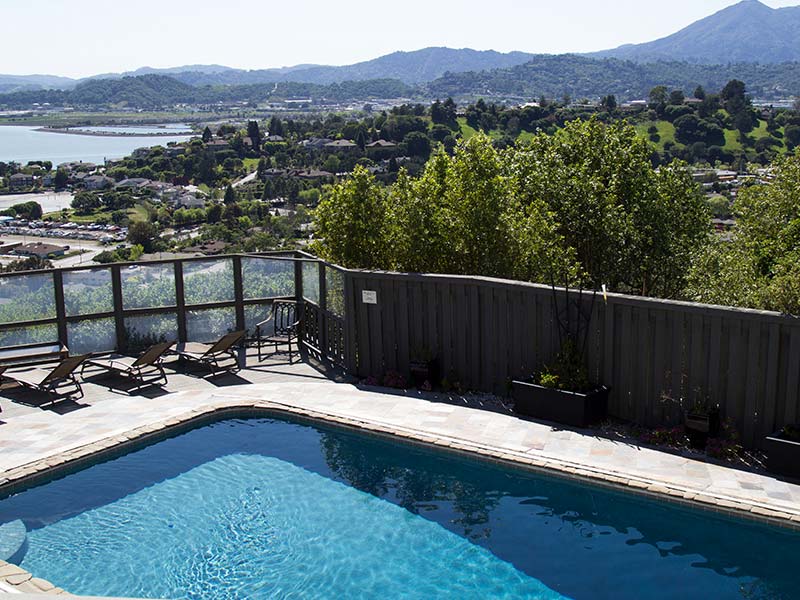 Outdoor pool overlooking hillside landscape and water in the distance