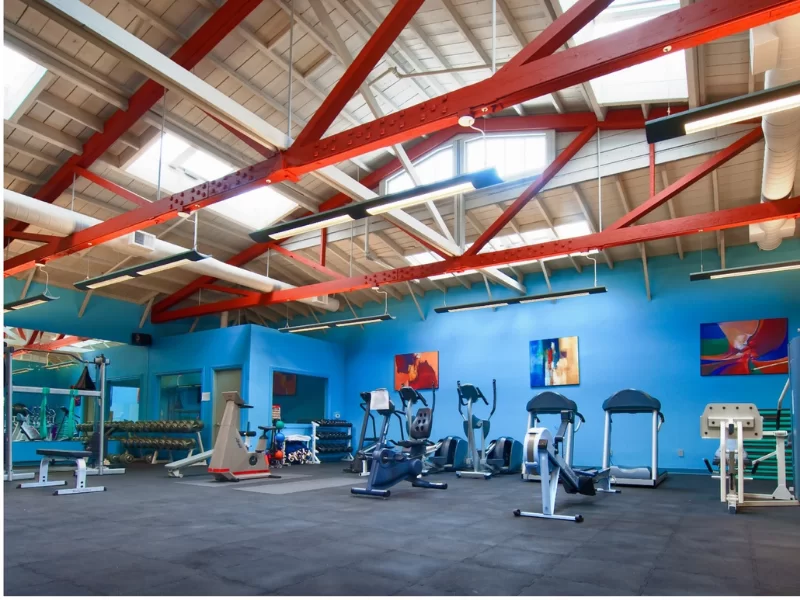 Spacious fitness room with exercise equipment and high ceilings
