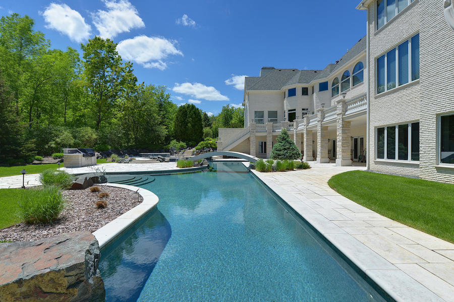 Outdoor pool surrounded by patio and garden