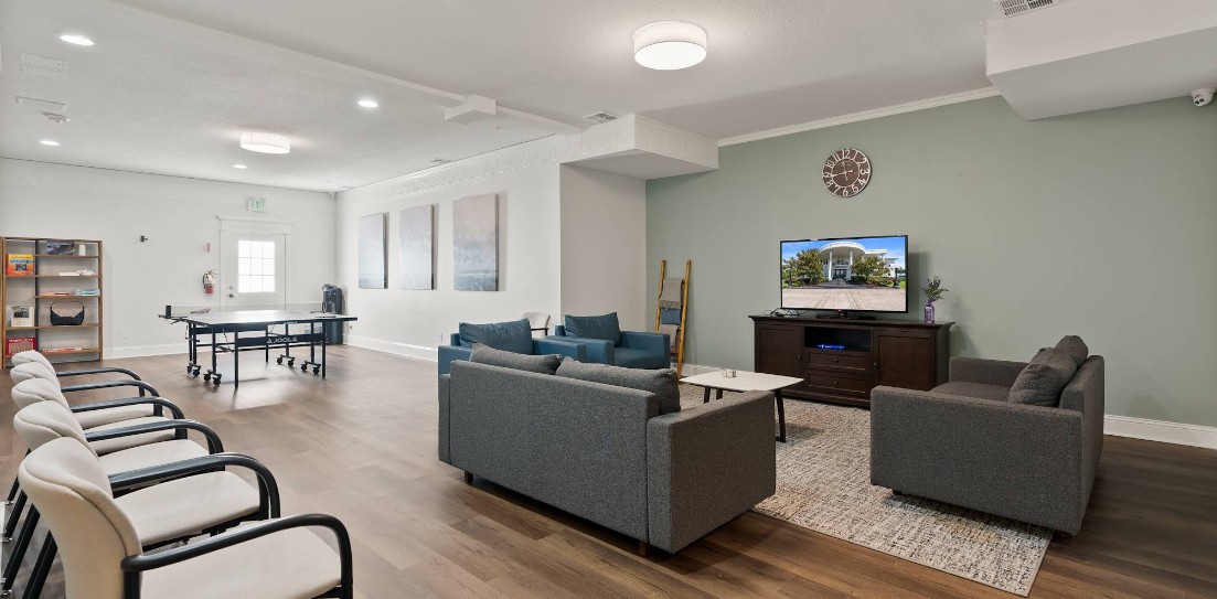 Recreation room with sofas, TV, and ping pong table
