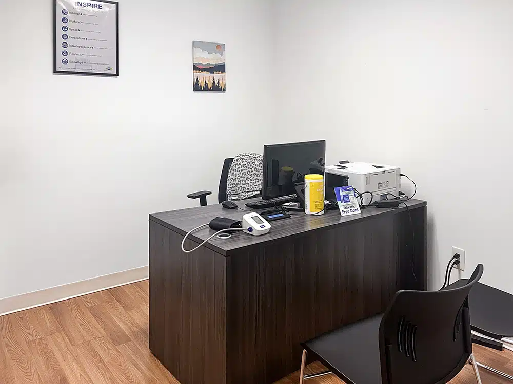 Counseling office with desk, computer, and medical equipment