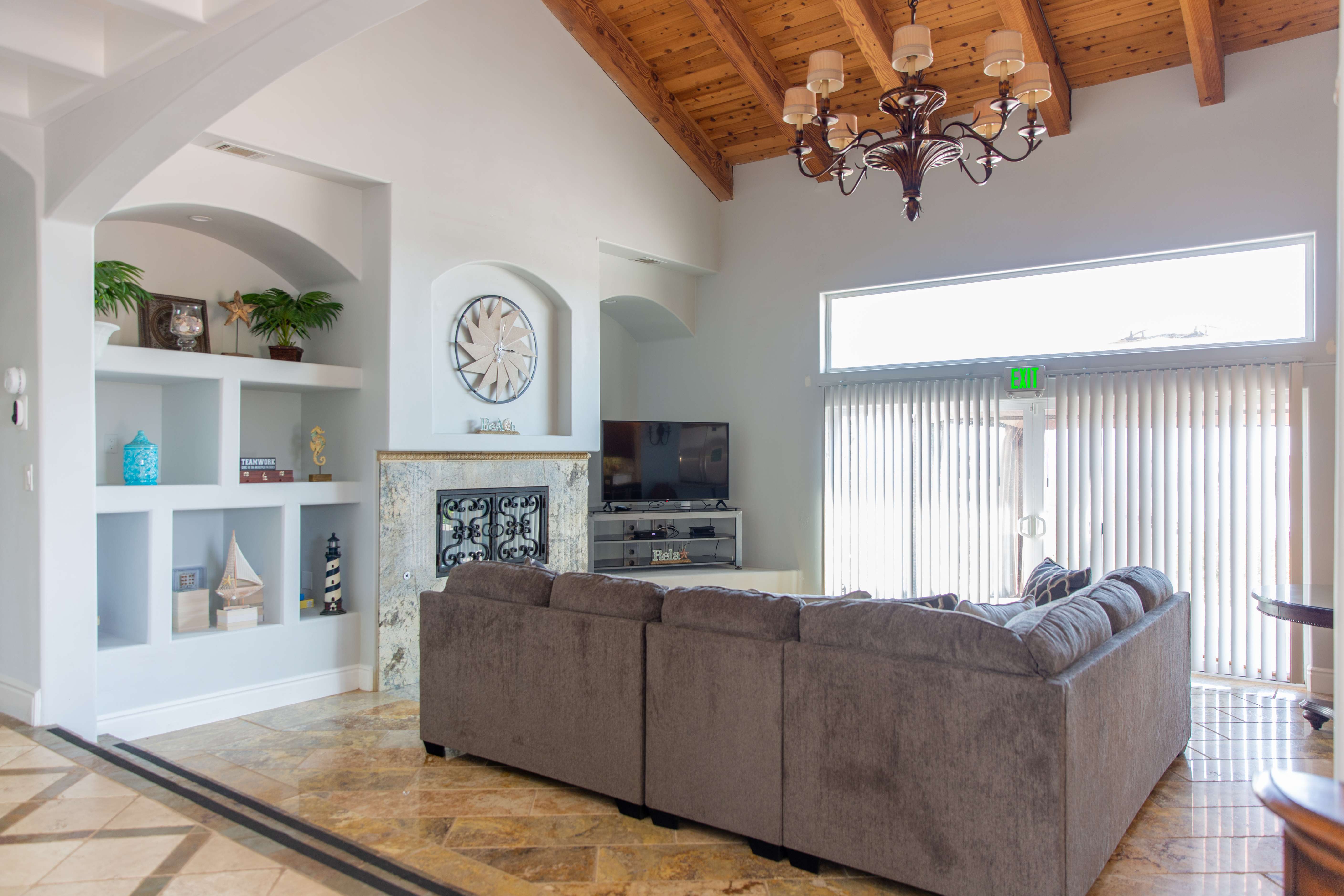 Spacious living room with gray sectional and wood beam ceiling