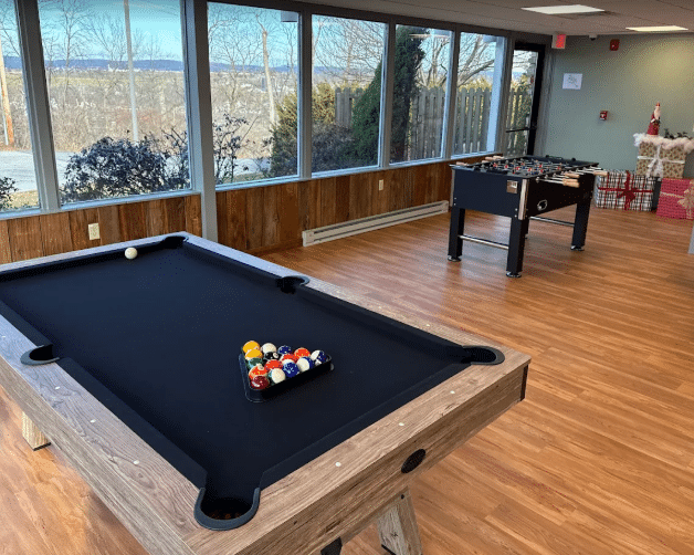 Game room with pool table and foosball near windows