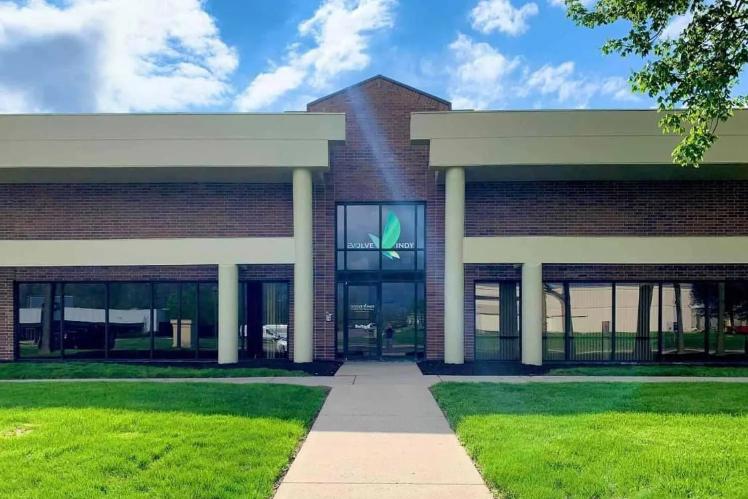 The front entrance of Evolve Indy rehab center with brick and glass design.