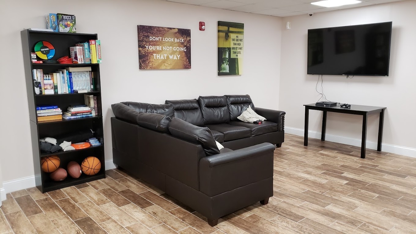  Lounge with black sectional sofa and bookshelf.
