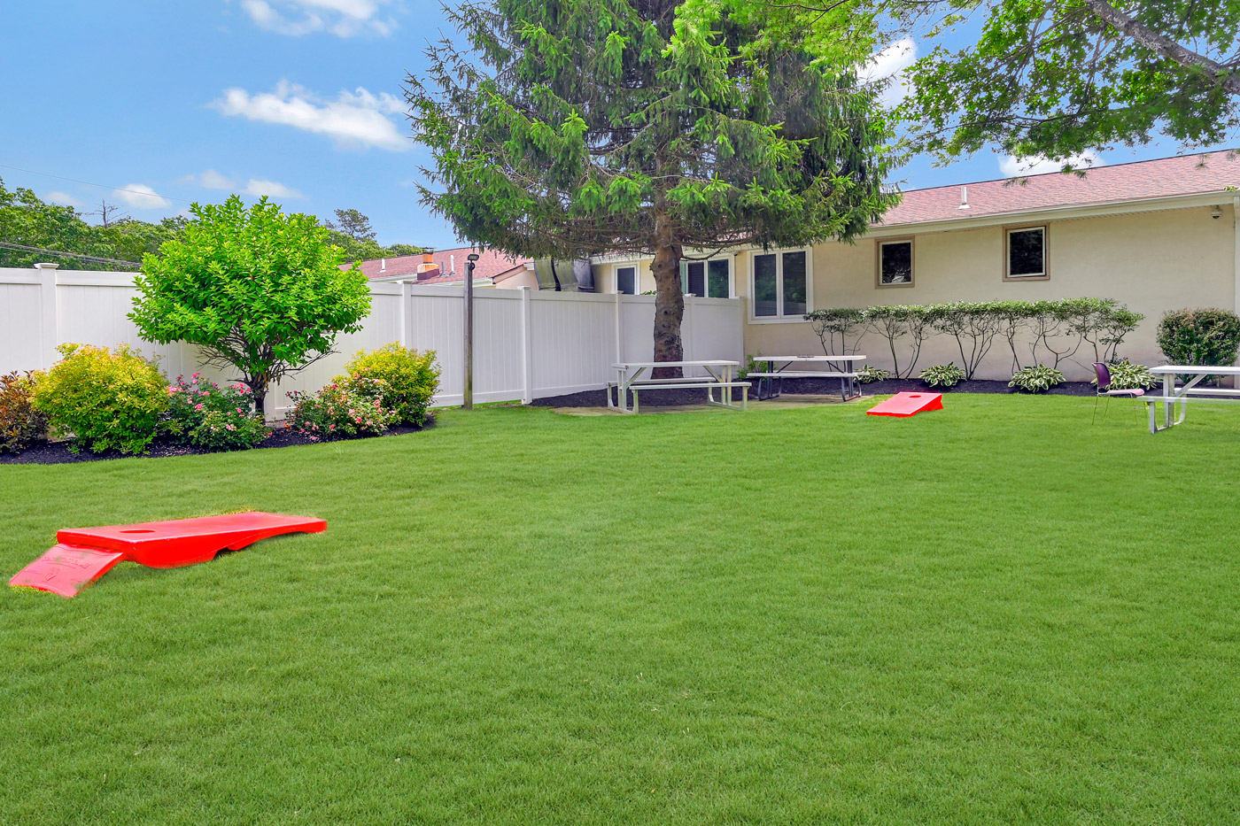 Open grassy courtyard with picnic tables and yard games