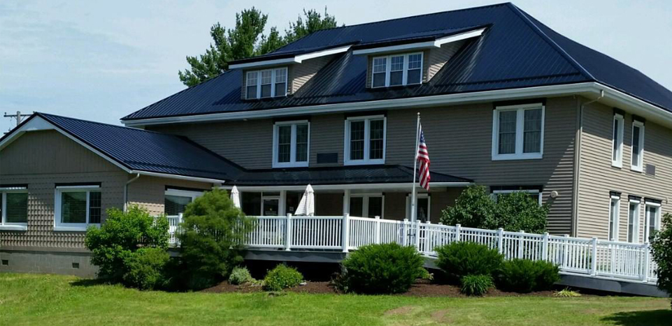 Two-story rehab facility with porch and landscaped front yard.