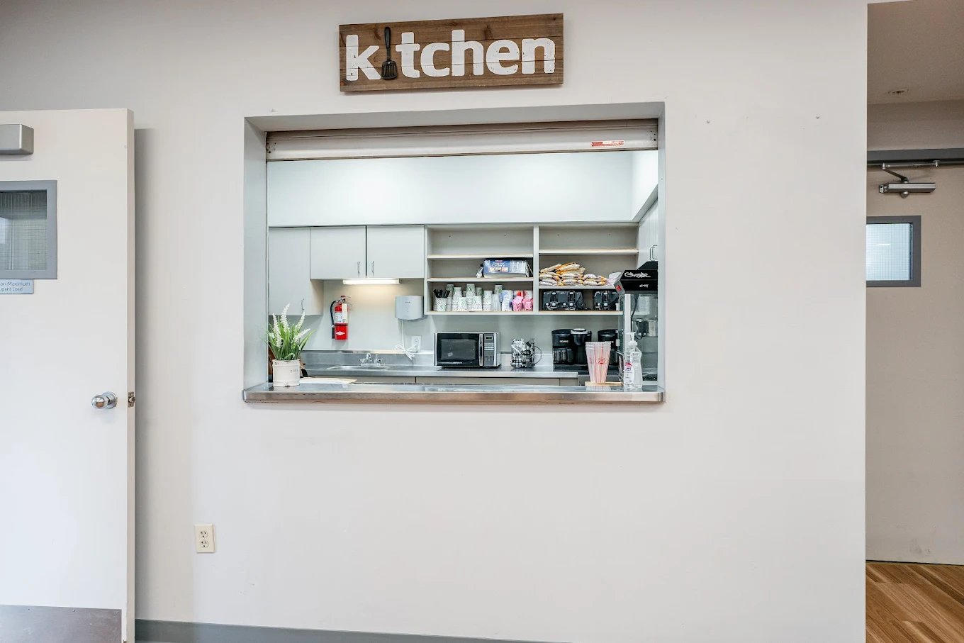 Kitchen service window with appliances and supplies