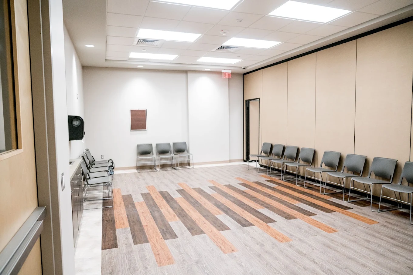 Spacious room with chairs along walls and patterned flooring