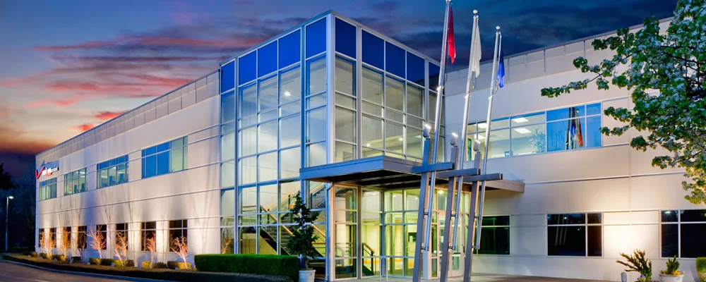 Exterior of the Hazelden Betty Ford Foundation facility in Beaverton at dusk, featuring a modern glass entrance and flagpoles
