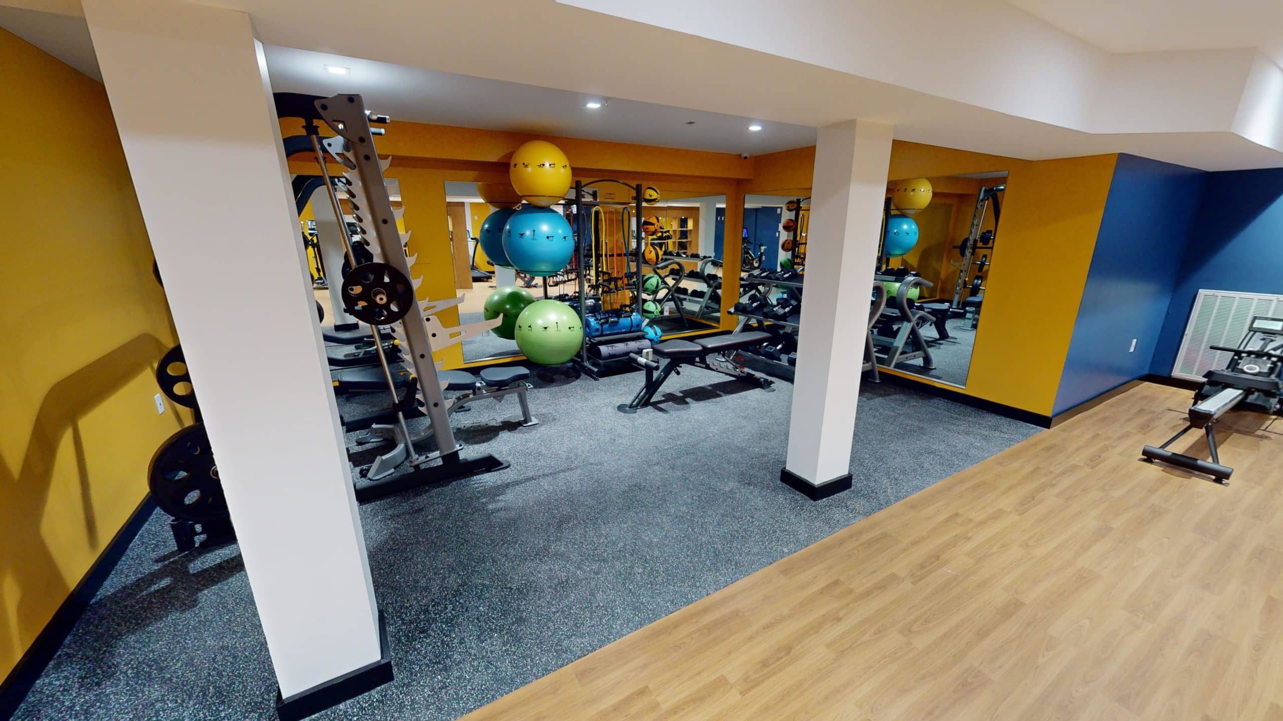 Gym with weights, equipment, and mirrored walls
