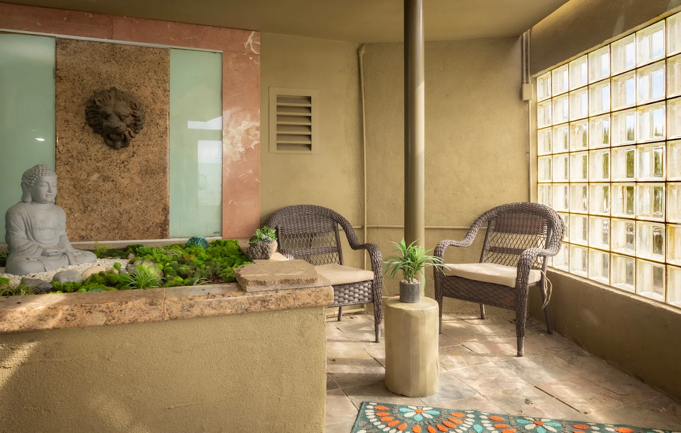Peaceful seating area with Buddha statue and rattan chairs
