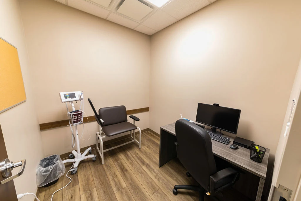 Private exam room with medical equipment and workstation