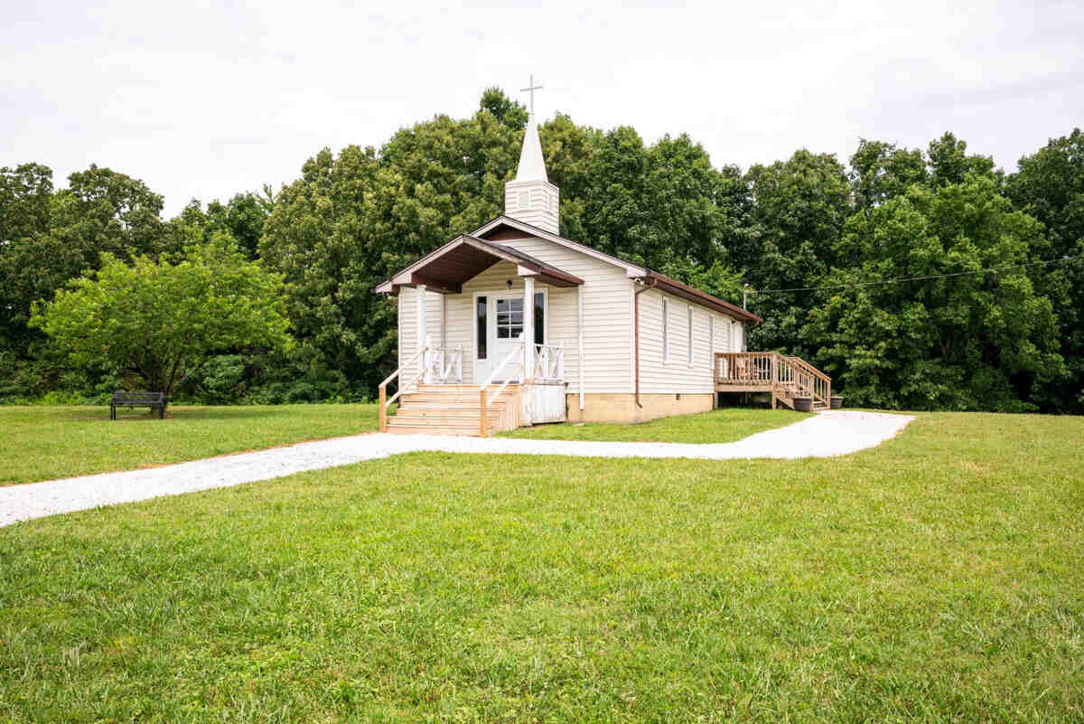 Church building with forest and maintained lawns