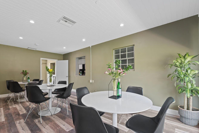 Round tables with black chairs and vases on each table