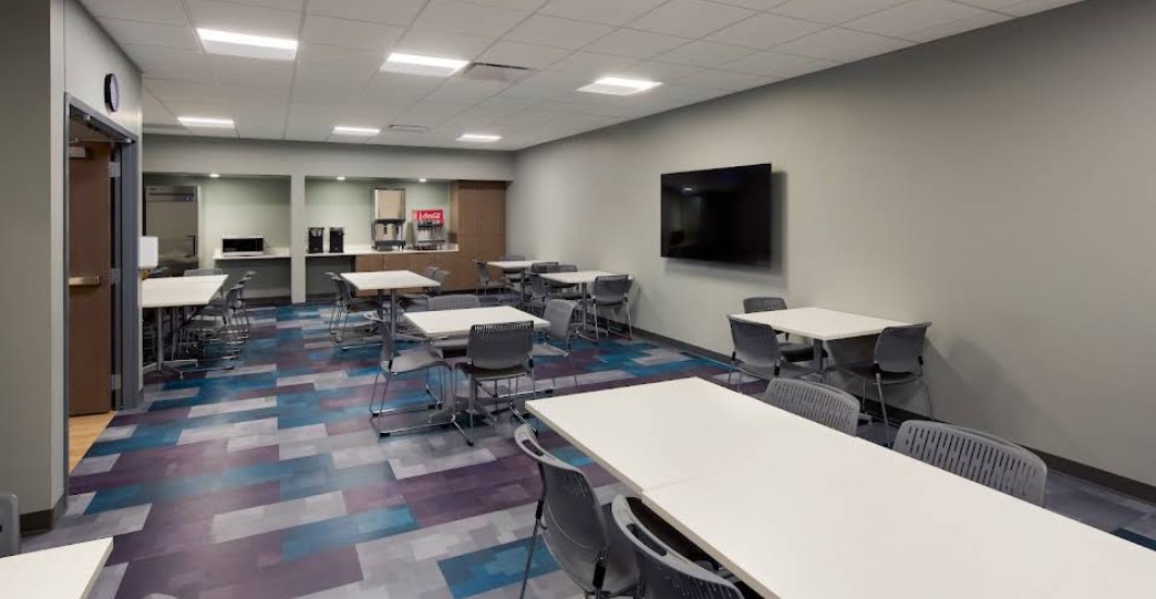 Dining and community room with tables, seating, and refreshments