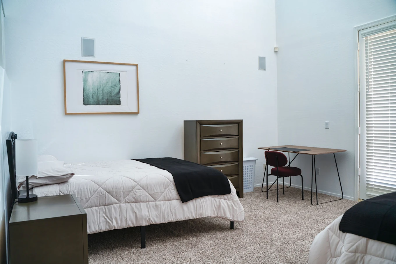 Shared room with two beds, dresser, and small desk