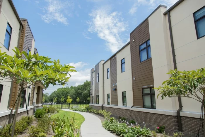 Courtyard path between modern buildings with trees and shrubs