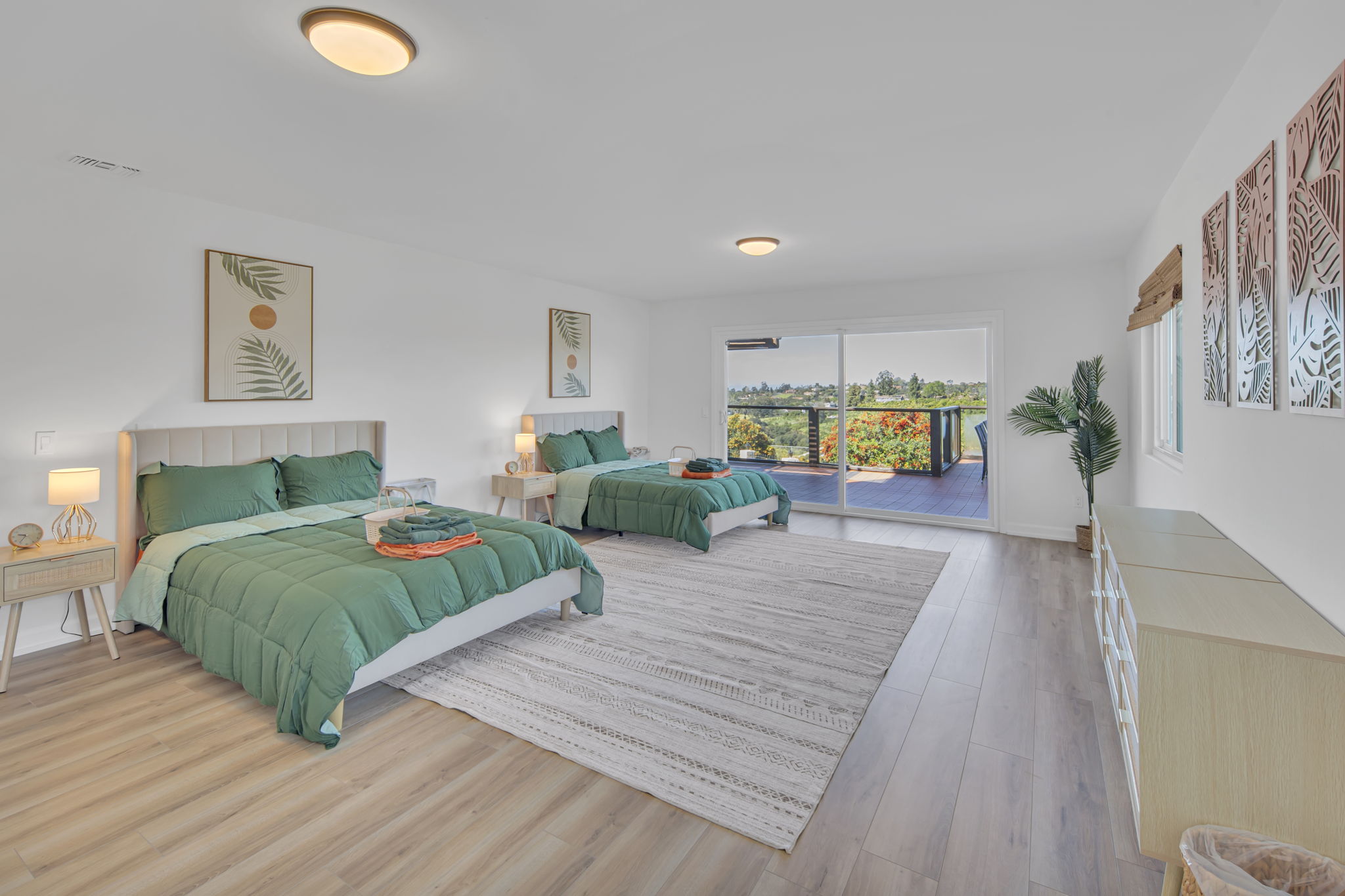 Spacious bedroom with green bedding and balcony view
