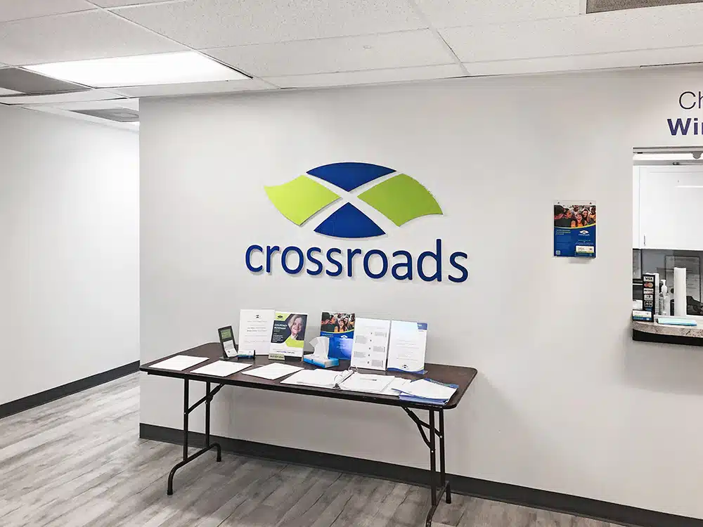 Reception area with brochures and Crossroads logo on wall