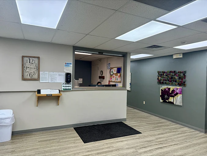 Reception desk beside a decorated wall and clock