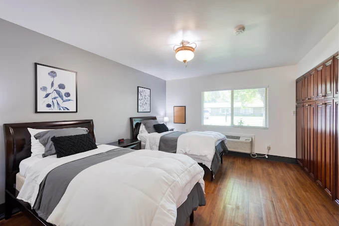 Shared bedroom with two beds and hardwood flooring
