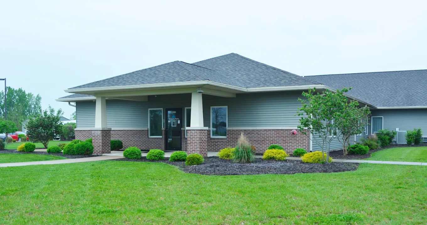 Single-story facility building with a landscaped front lawn
