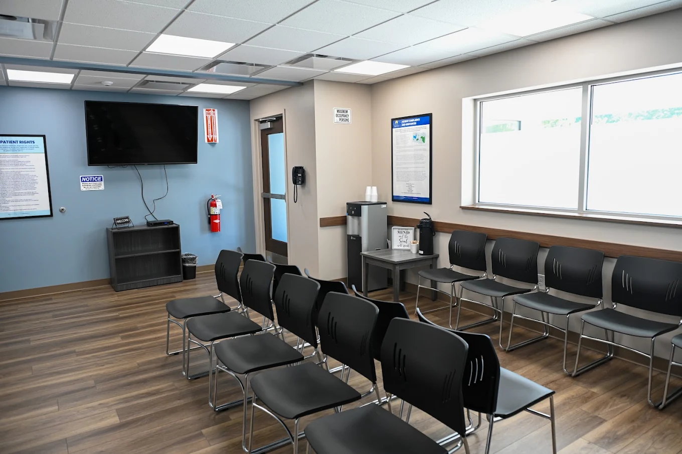 Main waiting room with seating, TV, and coffee station