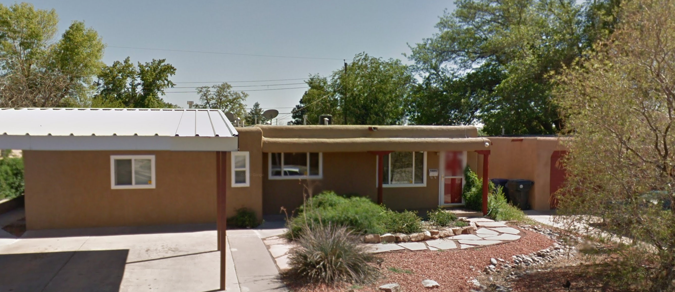 A single-story adobe-style detox center with a covered carport and desert landscaping.