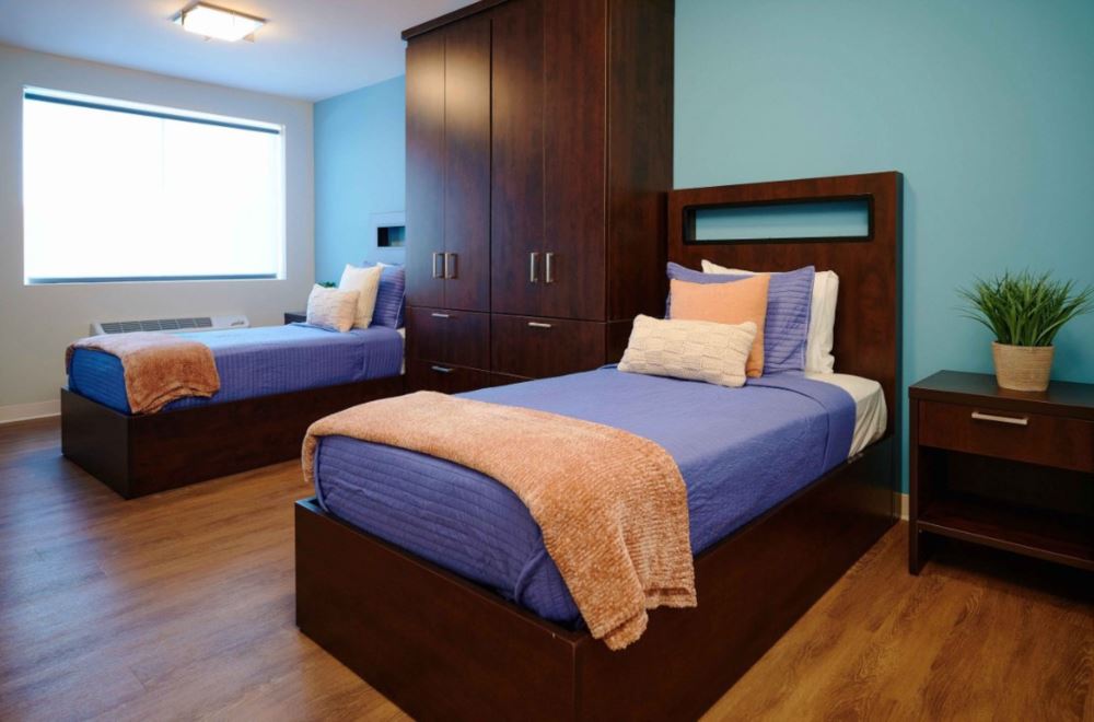 Shared bedroom with two twin beds and wooden furnishings