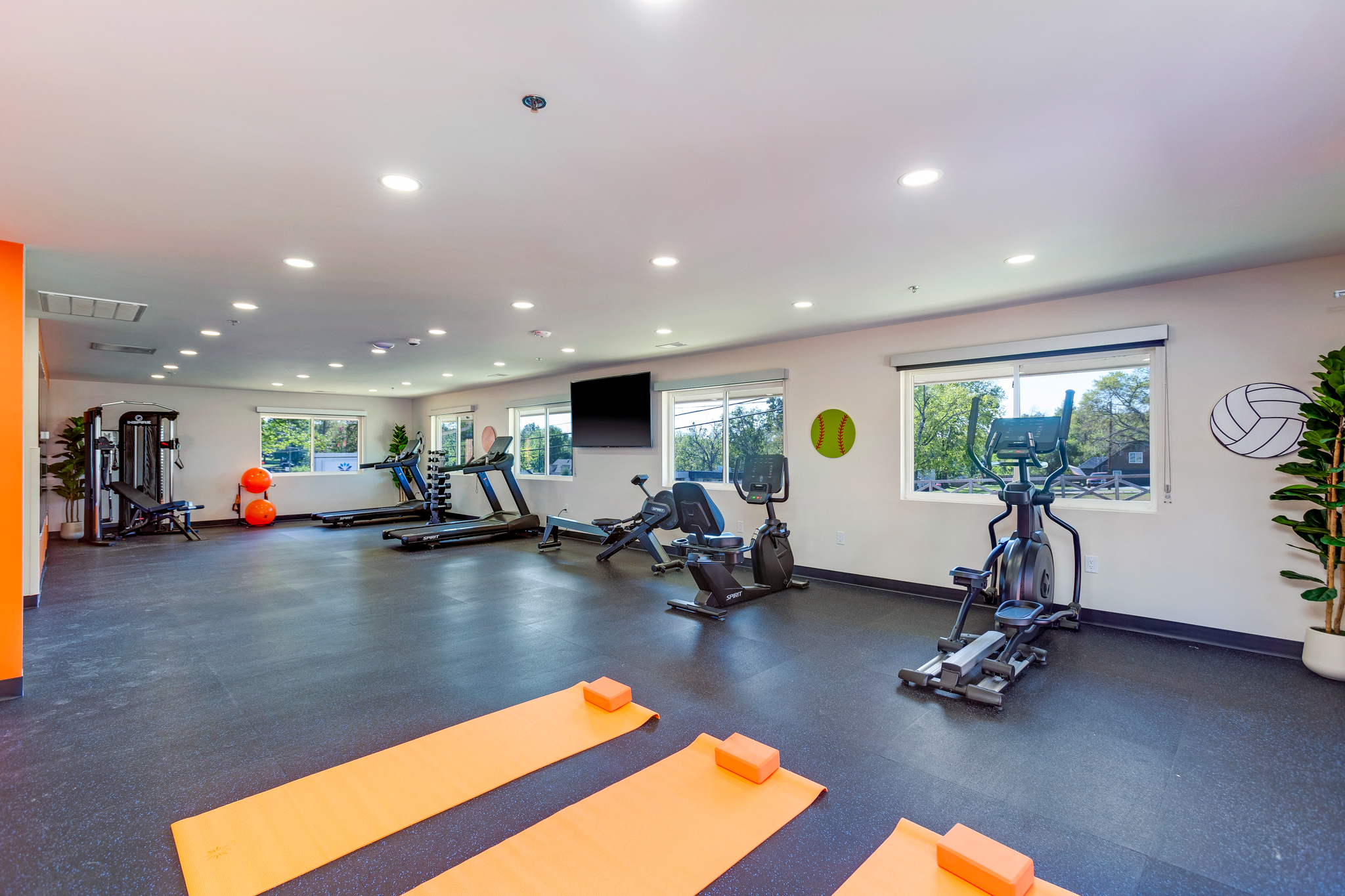 Fitness room with exercise bikes and orange yoga mats