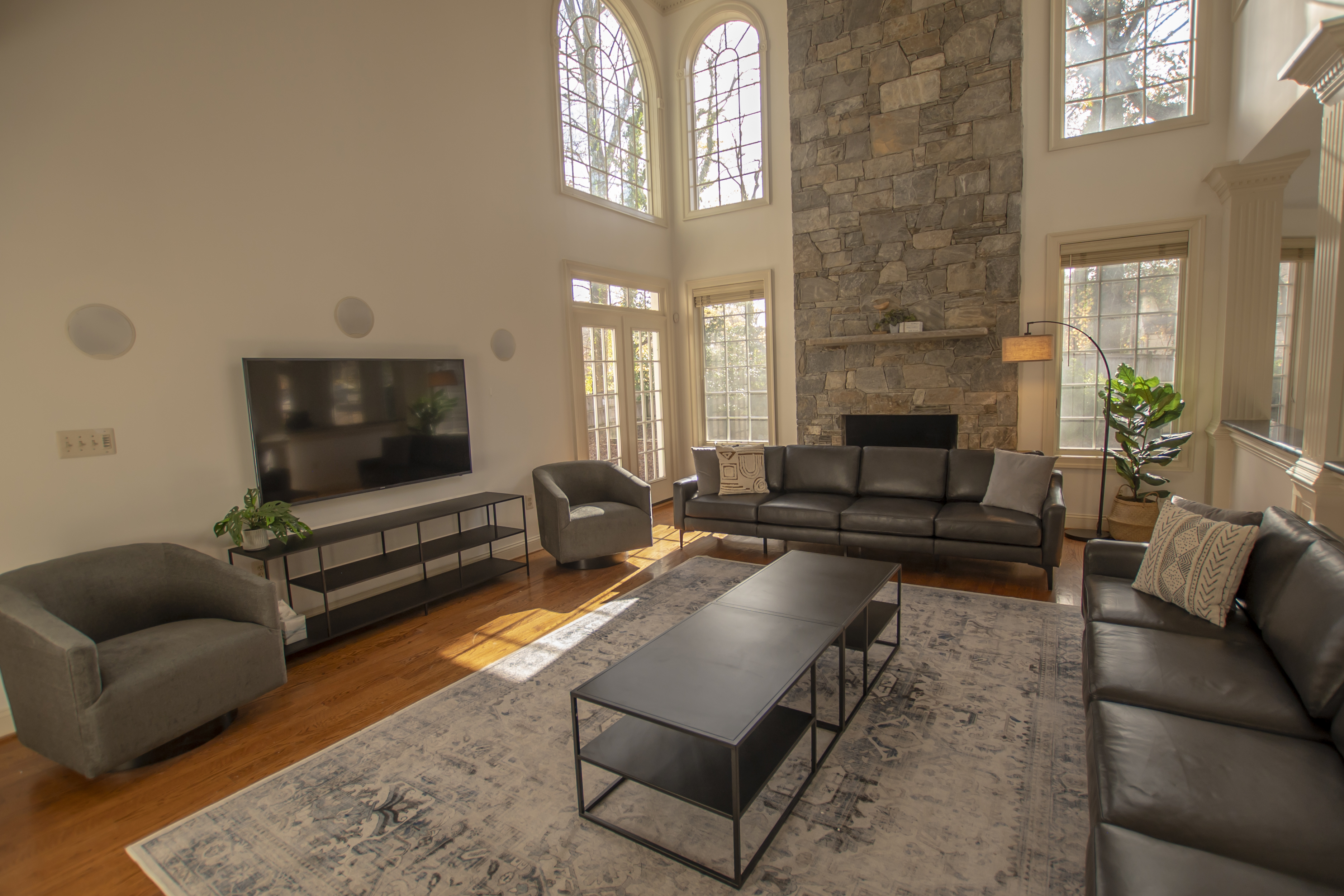 Large living room with stone fireplace and TV.