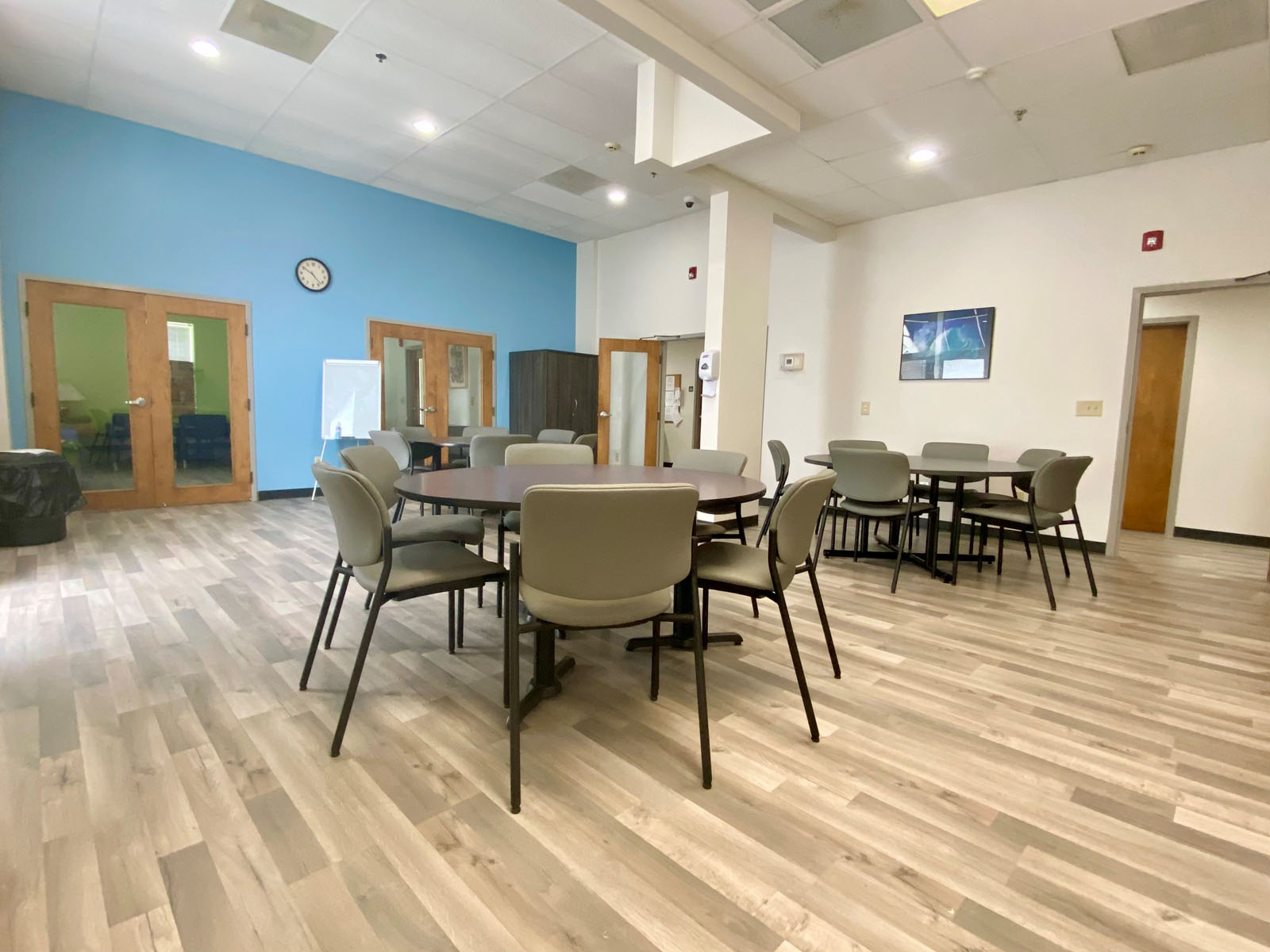Open dining area with tables, chairs, and high ceilings