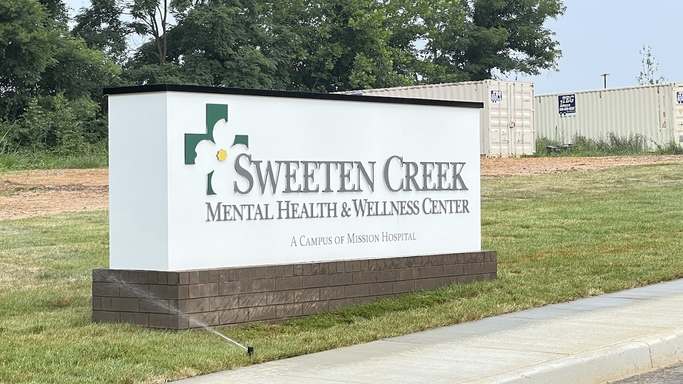Facility sign with logo and name on landscaped lawn