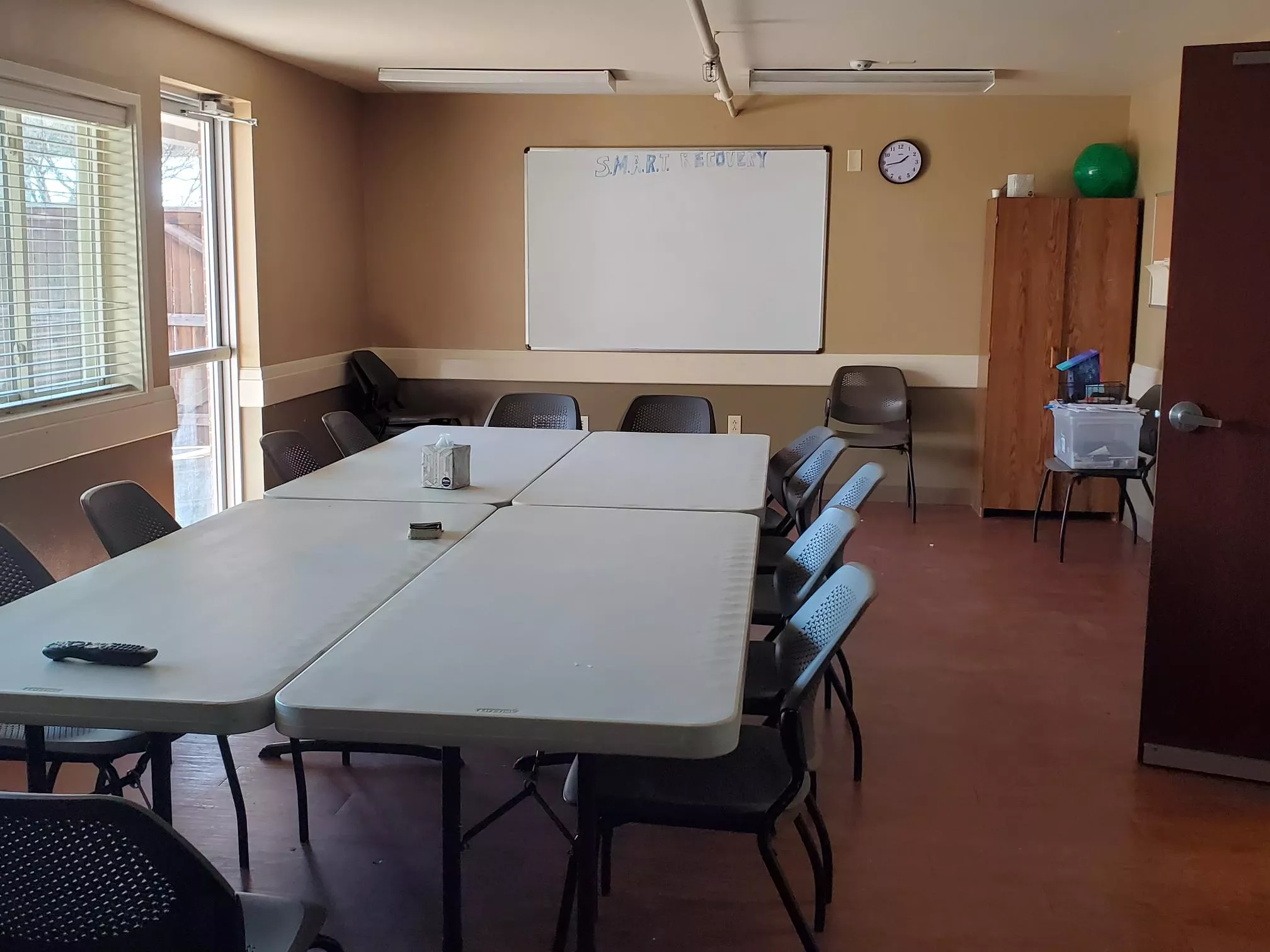 Group meeting room with tables, chairs, and a whiteboard