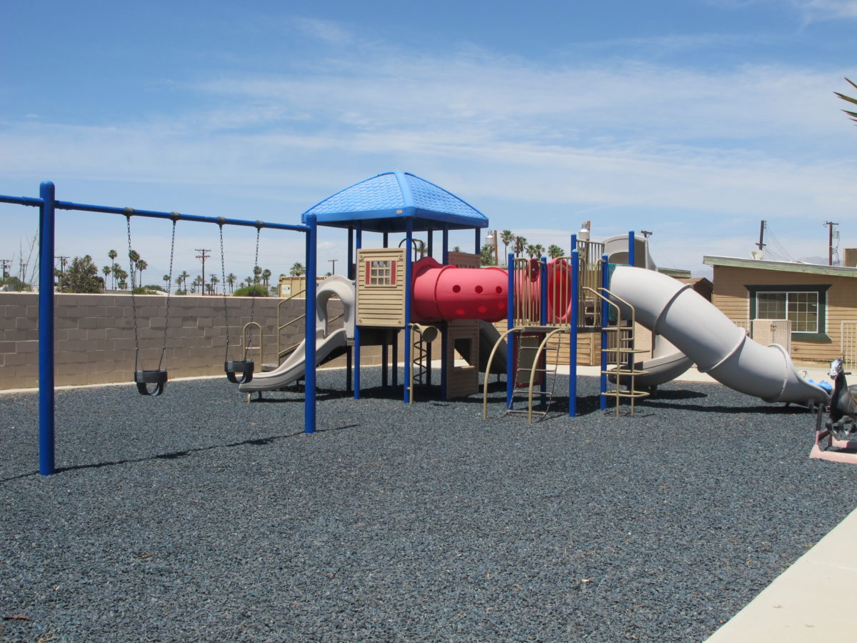 Outdoor play area with swings and slides.