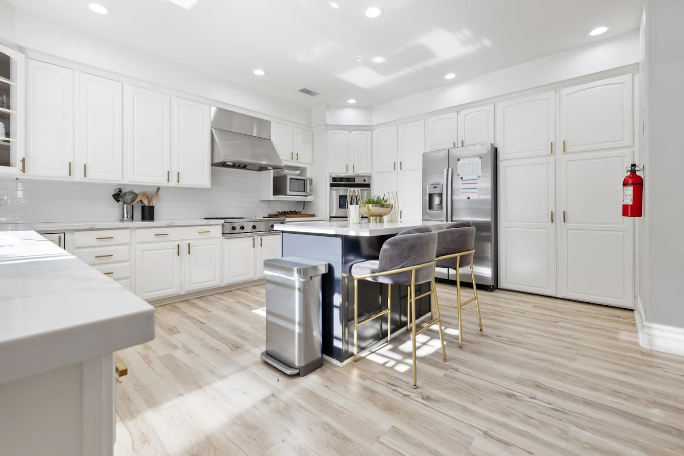 Full kitchen with white cabinetry and center island