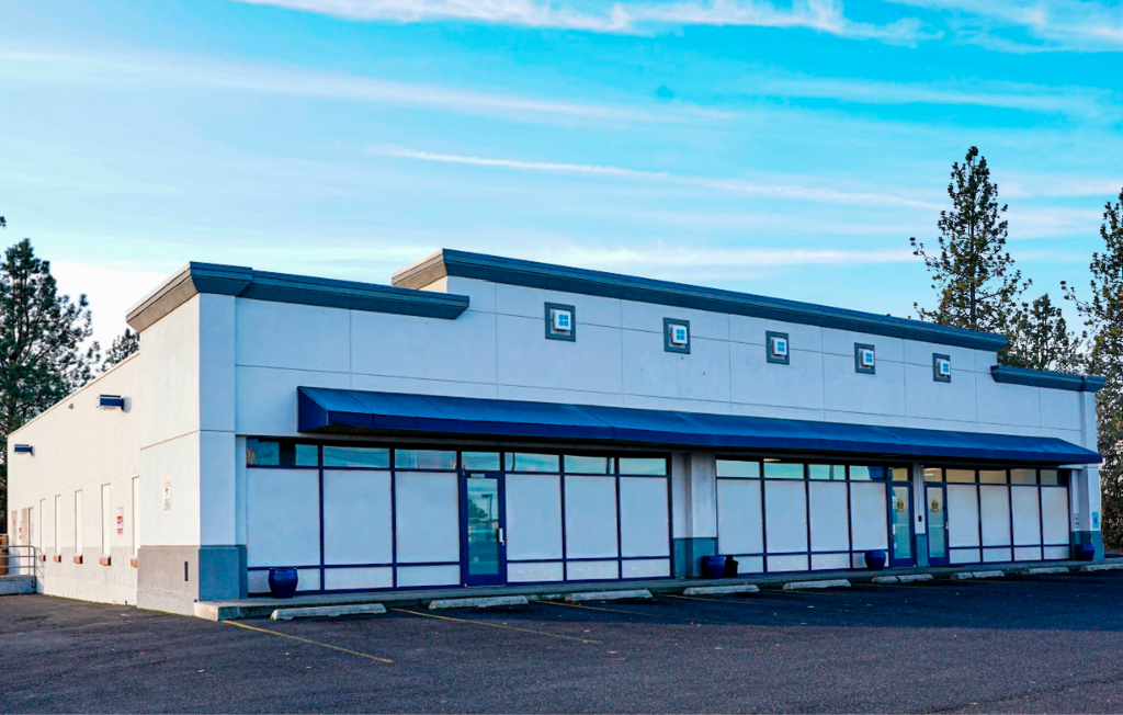 Large white building with blue trim and awnings