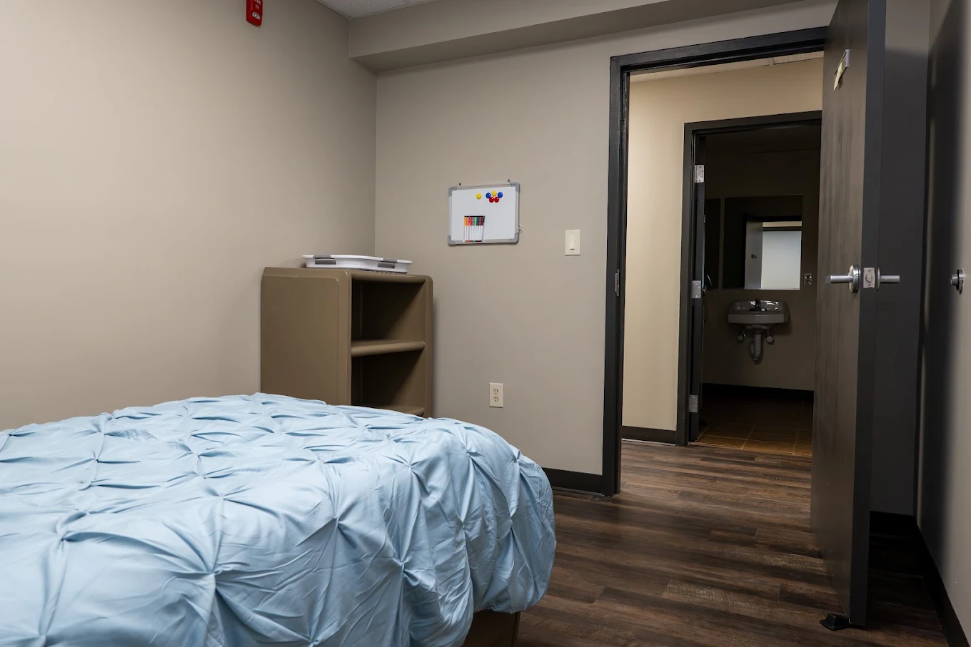 Private bedroom with bed, storage shelves, and bathroom